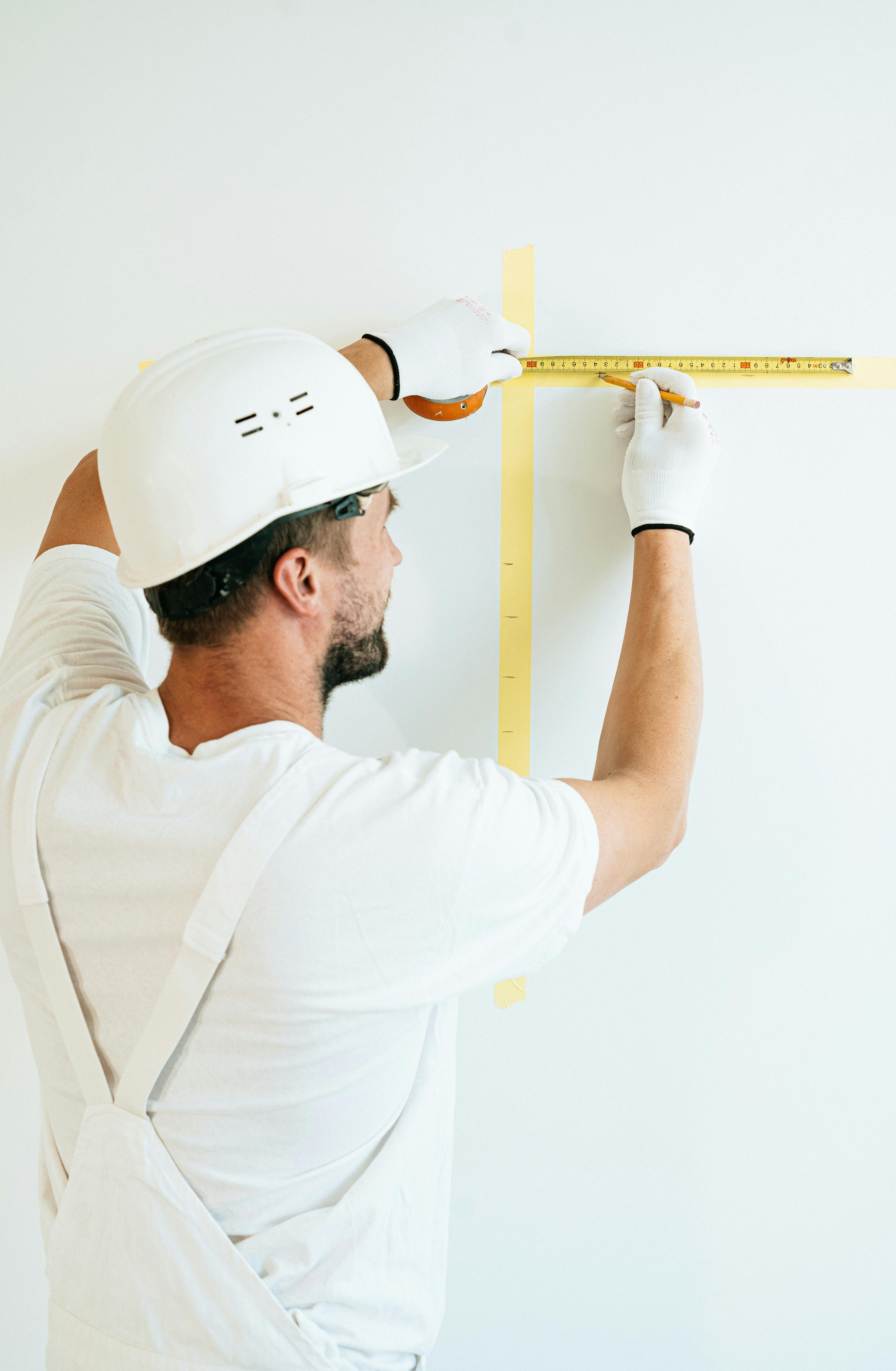 Un ouvrier prenant des mesures sur un mur